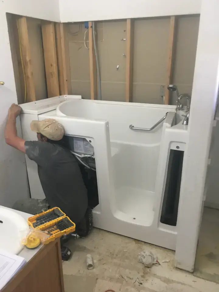 Installer fitting a walk-in tub into a bathroom (Walk-in tubs for Spring and Klein homes)