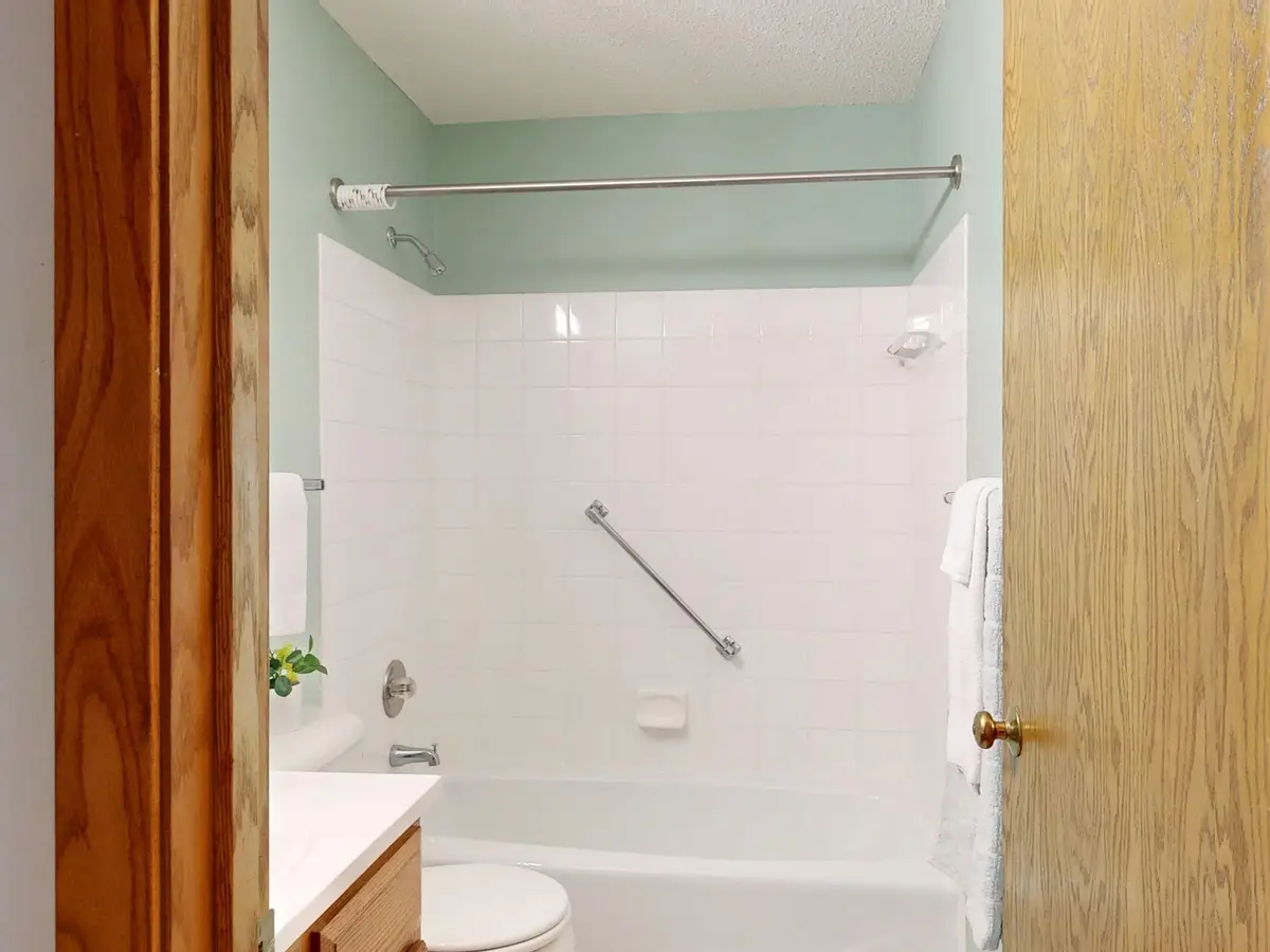 Bathroom with a tub, tile walls and a grab bar (Senior bathroom safety checklist for Houston homes)